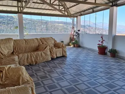 a living room with a couch in a room with windows at Jerusalen Inn-Dep 3 in Cusco