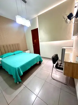 a bedroom with a green bed and a chair at Hotel Gboss in Punta Hermosa