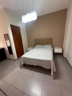 a bedroom with a bed with a white bedspread at Hotel Gboss in Punta Hermosa