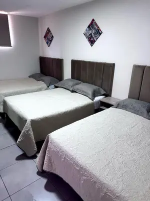 a room with three beds in a room at Hotel Gboss in Punta Hermosa