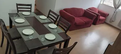 a dining room with a table and a red couch at Departamento 5p Lima Centro 3 dormitorios 4 camas in Lima