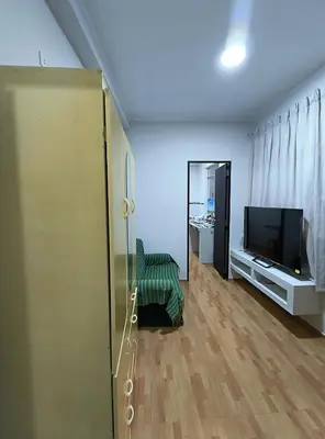a living room with a television and a chair at Mini departamento acogedor en el centro de Huánuco in Huánuco