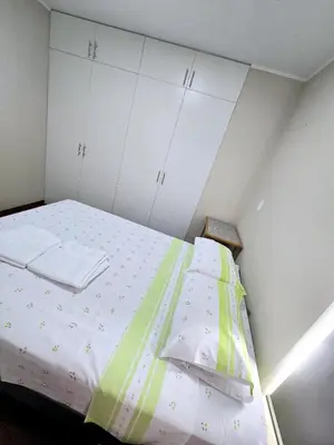 a bedroom with a large bed with white cabinets at Depa moderno - Aeropuerto, San Marcos, Católica in Lima
