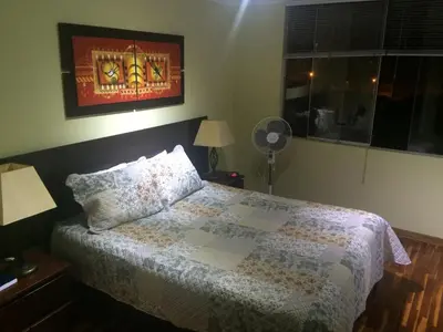 a bedroom with a bed and a window and a fan at Cozy Condo in Miraflores in Lima