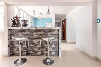 a kitchen with two stools in front of a stone counter at Apartamento en Cuzco in Cusco