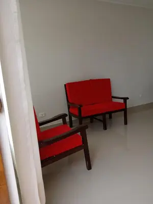 two red chairs sitting in a room at Huacachina house in Ica