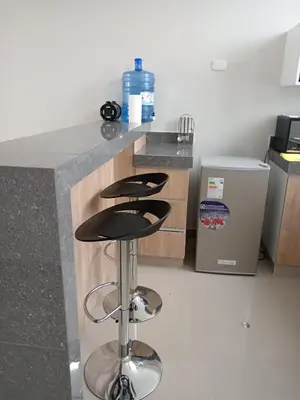 a kitchen with a counter with three bar stools at Huacachina house in Ica