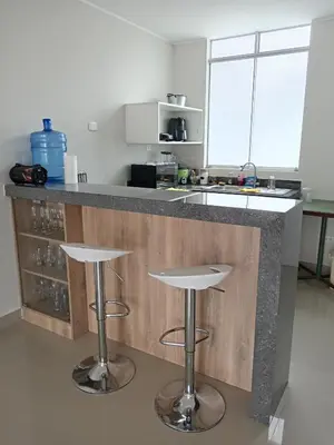 a kitchen with two bar stools and a counter at Huacachina house in Ica