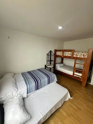 a bedroom with two beds and two bunk beds at DEPARTAMENTO FRENTE ARENa 1 in Lima