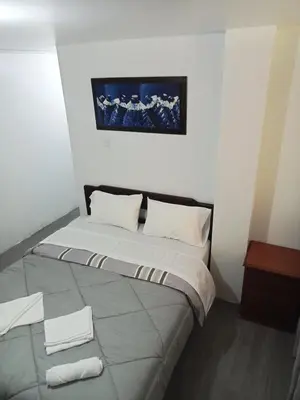 a bed in a room with towels on the floor at Departamento 2 HABITACIONES 1A in Lima
