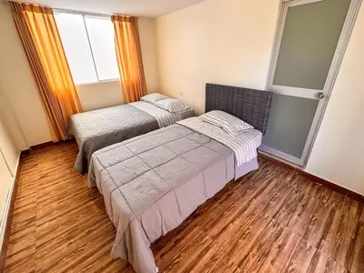 a bedroom with two beds and a window at Hotel Krammer en San Ramón, Selva Central in San Ramón
