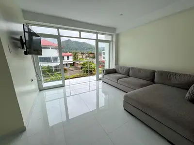 a living room with a couch and a large window at Hotel Krammer en San Ramón, Selva Central in San Ramón
