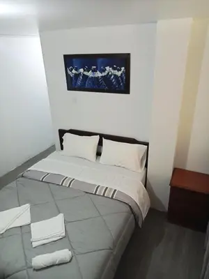 a bed in a room with towels on the floor at Habitación cama QUEEN 1B in Lima