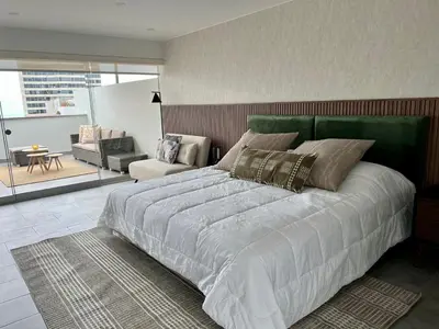 a bedroom with a large bed and a living room at Malecón Miraflores Luxury Penthouse in Lima