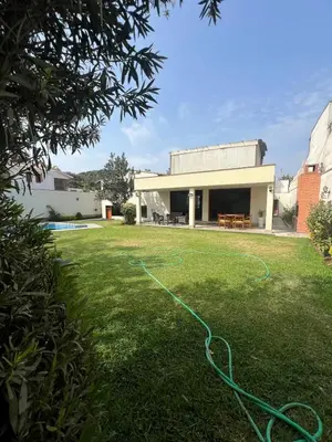 a yard with a green hose in front of a house at casa Alva in La Molina