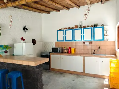 a kitchen with white cabinets and blue accents at Casa bonita en Playa Los Lobos in Cerro Azul