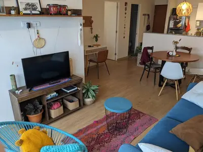 a living room with a blue couch and a tv at Acogedor y cómodo departamento de 2 Habitaciones en Magdalena in Lima