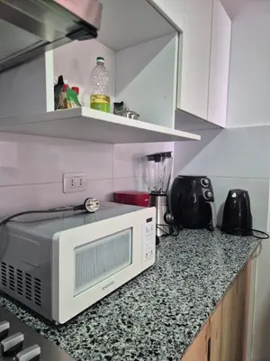 a kitchen with a microwave on a granite counter top at Apartamento Mary in Lima