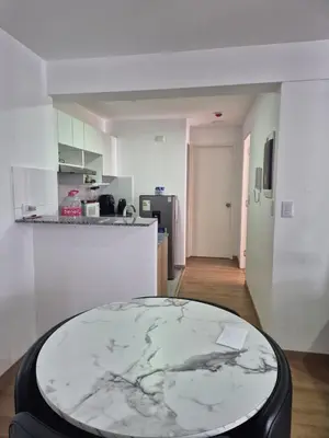 a living room with a table and a kitchen at Apartamento Mary in Lima