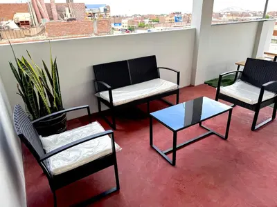 three chairs and a coffee table on a balcony at Cuzco Lodgement in Lima