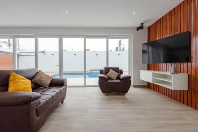 a living room with a couch and a flat screen tv at CA4 - Casa con Jacuzzi privado - Playa Pulpos in Punta Hermosa