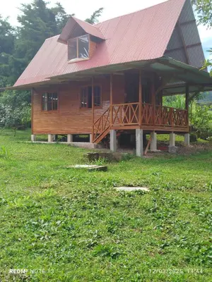 a large wooden house with a red roof at Yoly cabaña in Oxapampa
