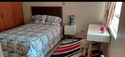 a small bedroom with a bed and a desk and a window at Confort Maruja in Lima