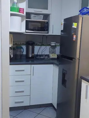 a kitchen with a refrigerator and a microwave at Confort Maruja in Lima