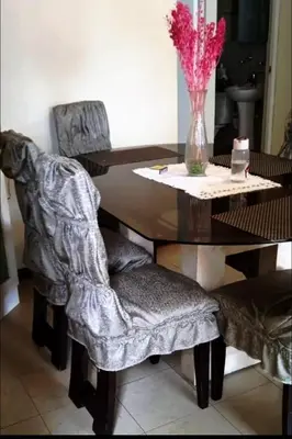 a dining room table with chairs and a vase of flowers at Confort Maruja in Lima