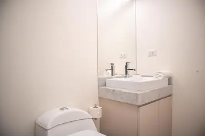 a bathroom with a toilet and a sink and a mirror at Art by Wynwood House in Lima