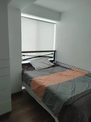a bedroom with a bed in a white room at Departamento de 3 habitaciones in Lima