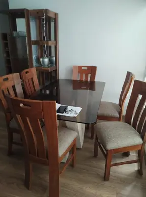 a dining room table with wooden chairs and a black table at Departamento de 3 habitaciones in Lima