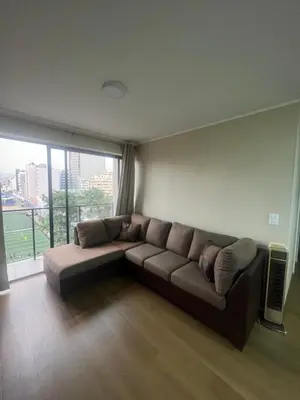 a couch in a living room with a large window at AMPLIO DEPARTAMENTO EN JESÚS MARÍa in Lima
