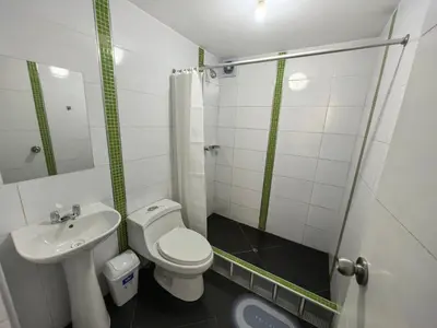 a small bathroom with a toilet and a sink at Hotel Douce Nuit in Huancayo