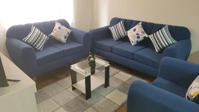a living room with two blue couches and a table at JTM Apartament in Cusco
