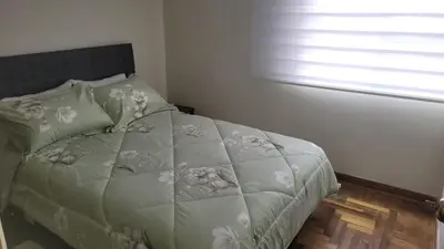 a bedroom with a bed with flowers on it at JTM Apartament in Cusco