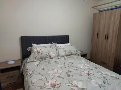 a bedroom with a bed with pink flowers on it at JTM Apartament in Cusco