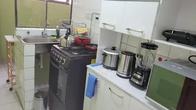 a small kitchen with a stove and a sink at JTM Apartament in Cusco