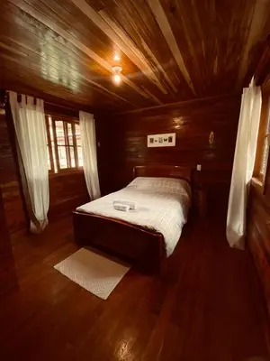 a bedroom with a bed in a wooden room at Yoly cabaña in San Francisco