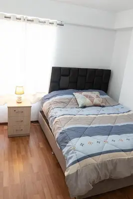 a bedroom with a large bed with a window at Departamento en el Corazón de Miraflores Peru in Lima