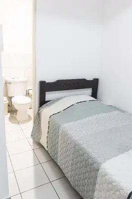 a white bedroom with a bed and a toilet at Departamento en el Corazón de Miraflores Peru in Lima