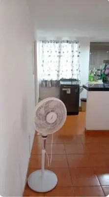 a white fan sitting on the floor of a kitchen at Departamento Acogedor en Surco in Lima