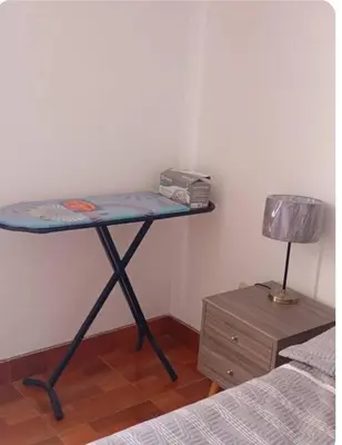 a table in a room with a bed and a lamp at Departamento Acogedor en Surco in Lima