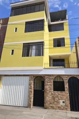 a yellow building with two garage doors at Florencia Lodgement in Lima