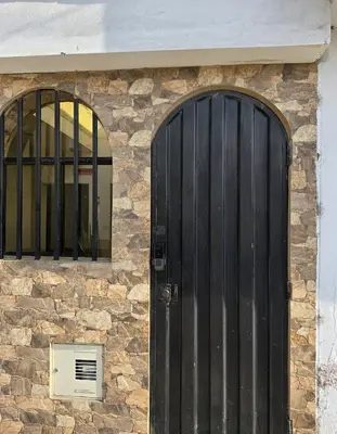 a building with a black door and two windows at Florencia Lodgement in Lima