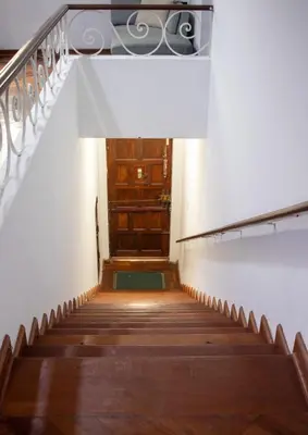 a stairway leading up to a wooden door at Gutierrez Hostel in Lima
