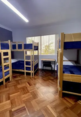 a room with four bunk beds and a wooden floor at Gutierrez Hostel in Lima