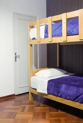 two bunk beds in a room with a door at Gutierrez Hostel in Lima