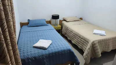 two beds sitting next to each other in a room at Apartment 10 minutes from the airport in Lima