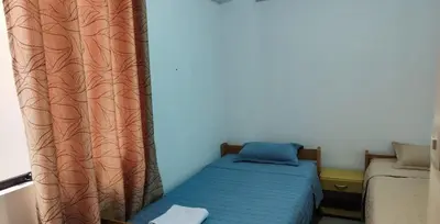 a small bedroom with a bed and a curtain at Apartment 10 minutes from the airport in Lima